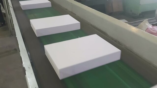 Cut pack A4 sized copier papers are passing though conveyor belt before cover is made. Automated copier manufacturing process in a paper manufacturing plant, India.