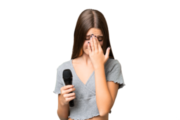Teenager singer girl picking up a microphone over isolated background with tired and sick expression