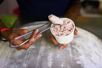Vendor, hands and treat with ice cream, rolls and sweet street food for Thailand market. Small business, entrepreneur and organic produce for nutrition, eating and fresh cuisine in asian road stall