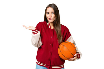 Young beautiful woman playing basketball over isolated chroma key background having doubts while raising hands