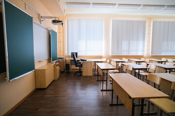 School desks in a row facing the blackboard in an empty classroom