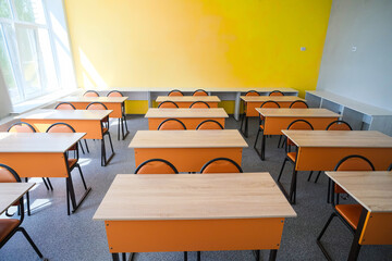 School desks in a row facing the blackboard in an empty classroom