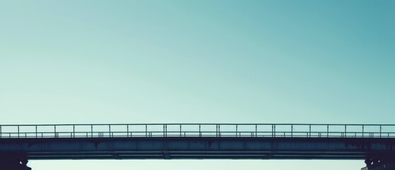 A bridge with a railing and a blue sky in the background