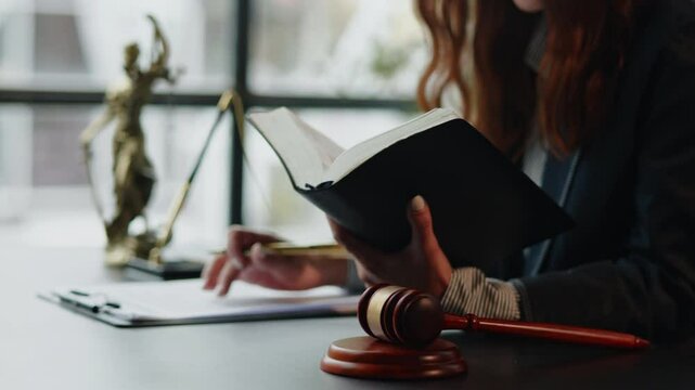 lawyer reading law book and writing and discuss contract  matters of law and contract for clients prepare for the trial.