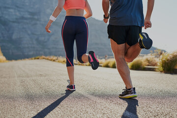 Running, fitness and legs or people in nature for exercise, warm up and marathon training together. Woman, man or sports coach back in mountains, trail or wellness workout support or challenge