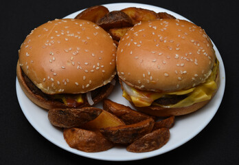 Hamburgers and homemade potatoes on a white plate. Delicious breakfast. Fast food.