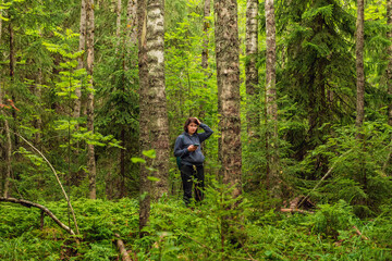 Naklejka premium A woman is trying to navigate in the forest