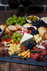assorted cheeses, fresh fruits and meats, vertical top view