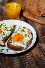 breakfast, sandwiches with fried egg on rye bread and orange juice, vertical