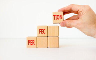 Perfection symbol. Concept word Perfection on beautiful wooden cubes. Businessman hand. Beautiful...