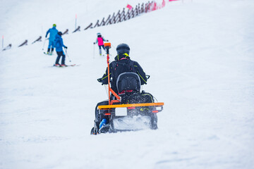 Rescuer man driving snowmobile on the ski resort.