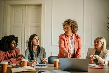 Shot of a mature businesswoman giving a presentation to her coworkers in the office board room