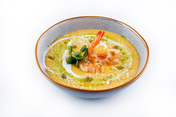 Pumpkin soup with shrimp on a white background.