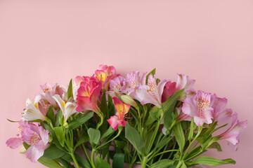 a bouquet of garden flowers on a pink background, a copy of the space