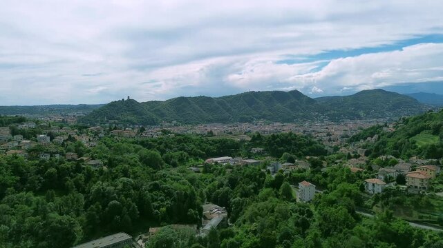 aerial view with fly up revealing effect of Spina verde mountains that around the Como city with Baradello tower in evidence