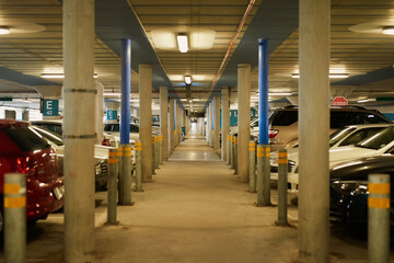 Cars, walkway and parking lot with pillars of public vehicles, transport or underground path at airport. Concrete structure, alley or passage with columns in transportation sector or basement garage