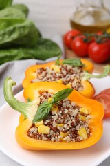 Quinoa stuffed bell pepper with basil on table, closeup