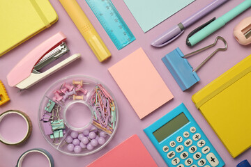 Flat lay composition with notebooks, stapler and different stationery on violet background