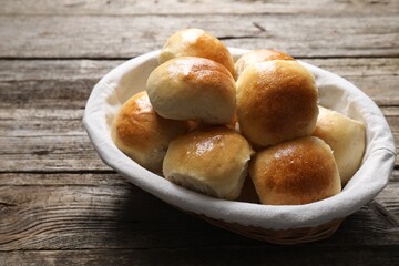 Delicious dough balls in basket on wooden table