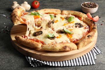 Taking piece of delicious vegetarian pizza at grey table, closeup