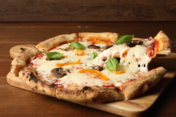 Taking piece of delicious vegetarian pizza at wooden table, closeup