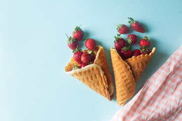summer background concept waffle cones filled with strawberry  on  blue copy space