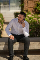 Hombre joven con traje y camisa en sitio lujoso con mar. Business man. Trabajando con tablet y...