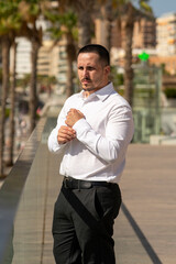 Hombre joven con traje y camisa en sitio lujoso con mar.  Business man. Trabajando con tablet y...