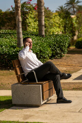 Hombre joven con traje y camisa en sitio lujoso con mar.  Business man. Trabajando con tablet y...