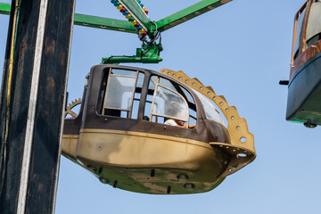Fototapeta premium An image showcasing an enclosed amusement park ride suspended and rotating in the air, presenting a unique and thrilling experience for the riders.
