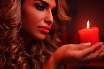 Fototapeta premium Young fashion woman home night dark portrait with candle
