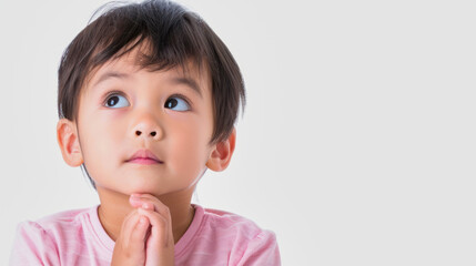 cute Chinese boy in thinking pose against white background with copyspace