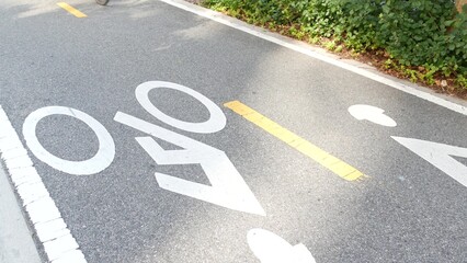 Fototapeta premium Bike lane asphalt sign, New York City. Bicycle path, cycle route for bicyclists, Manhattan. Way for roller skating and skates. Recreational sport activity infrastructure, biker cycling, United States.