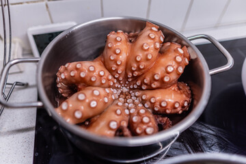 Boiled octopus is taken out of the pan.