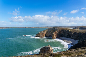 La mer d'Iroise s'étend au pied d'un majestueux massif rocheux sur la presqu'île de Crozon en Bretagne, offrant un spectacle naturel époustouflant entre terre et océan.