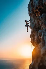 Gordijnen A climber, silhouetted against the sunset, scales a cliff, exemplifying freedom and extreme sport. © Andrii Zastrozhnov