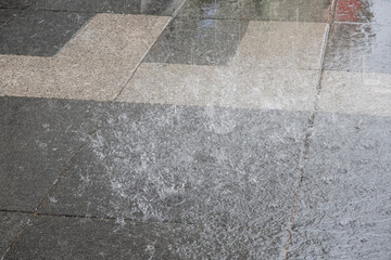 Splashes from drops of water on paving slabs during heavy rain