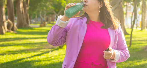 Woman Relaxing with a Drink in a Green Park