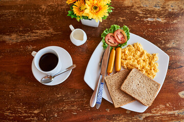 Coffee, bread and scrambled eggs on plate from above for healthy eating, breakfast and food in restaurant. Summer, flowers and meal in diner for hospitality, hosting and brunch at hotel for hunger