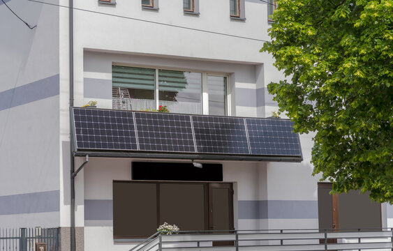 Słoneczna &bdquo;elektrownia&rdquo; na balkonie, fotowoltaika w mieście. Panel fotowoltaiczny wytwarzający prąd, zainstalowany na balkonie zabytkowej kamienicy miejskiej.