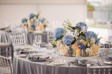 The elegant wedding table ready for guests. wedding table decorated with decorative and elegant for wedding. There are flowers, candles and serving plates on the wedding table.
