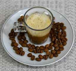 Espresso coffee served in a transparent cup with roasted coffee beans. Gourmet, 100% Arabica special