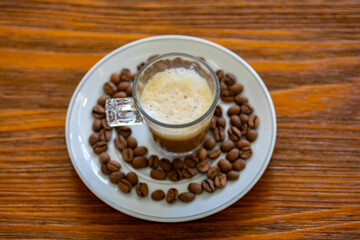 Espresso coffee served in a transparent cup with roasted coffee beans. Gourmet, 100% Arabica special