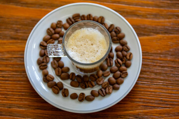 Espresso coffee served in a transparent cup with roasted coffee beans. Gourmet, 100% Arabica special