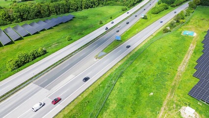 Drone view of the German motorway a7 with some cars and traffic in a green landscape.