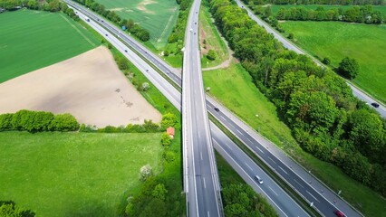 Drone view of the German motorway a7 with some cars and traffic in a green landscape.