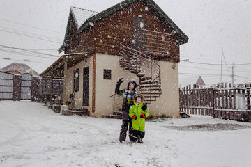 Children playing outdoors on a snowy winter day, laughing, having fun