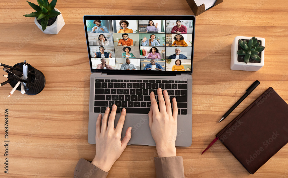 Poster lady uses a laptop for an online meeting with multiple participants. the laptop is open and the scre