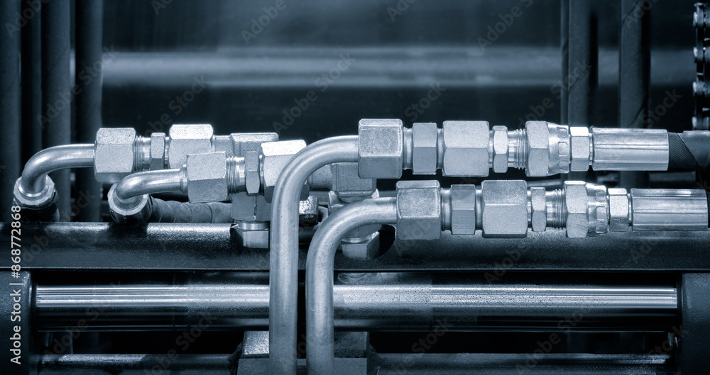 Poster a series of pipes are shown in a close up. the pipes are silver and appear to be connected to a larg