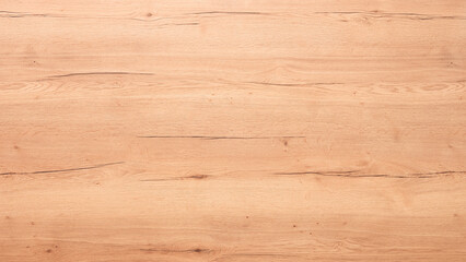 A wooden surface with a grainy texture. The wood is light brown and has a natural look, wooden texture background